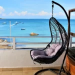 fauteuil balançoire sur la terrasse avec la mer derrière