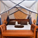 lit double à baldaquin moustiquaire, tables de nuit et bout de lit