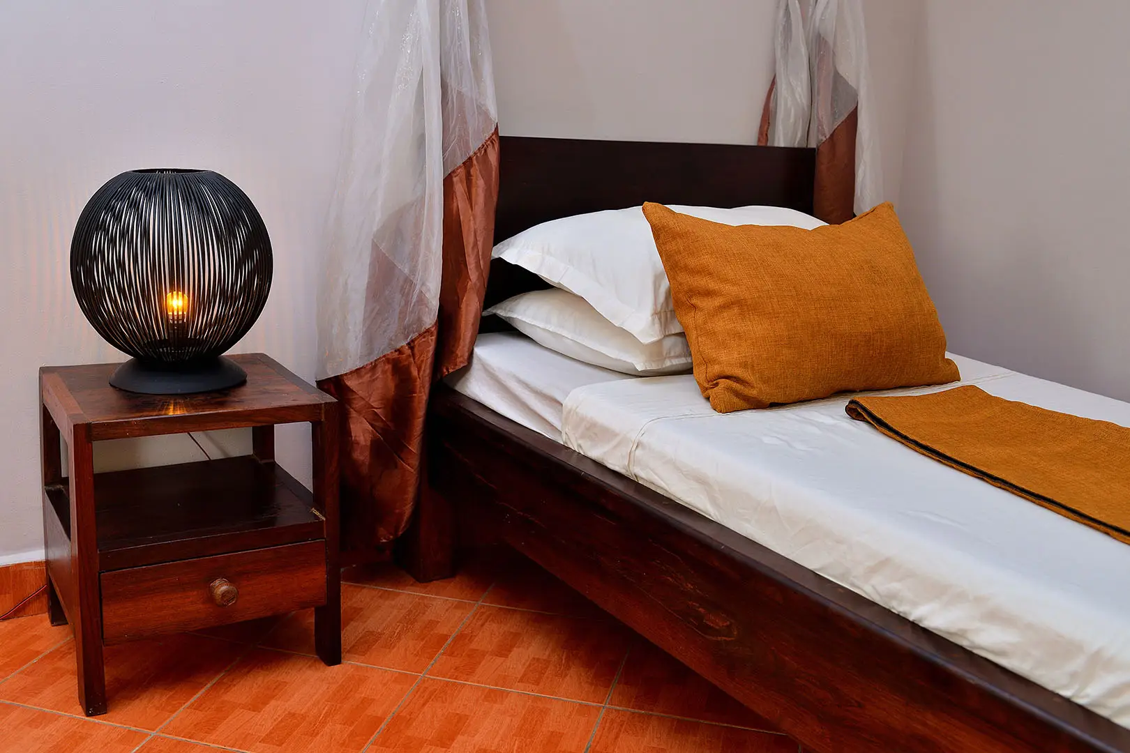 lit simple à baldaquin moustiquaire et sa table de nuit