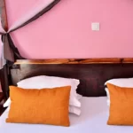 détail du lit et de la table de nuit avec mur rose